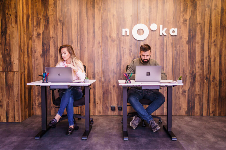 two people at desks in coworking space
